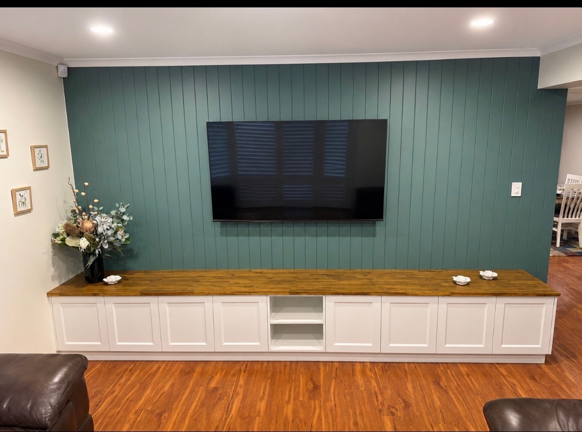 Full-wall built-in entertainment unit with teal feature wall, butcher-block timber top, white Shaker doors and open shelving — PMG Cabinetry