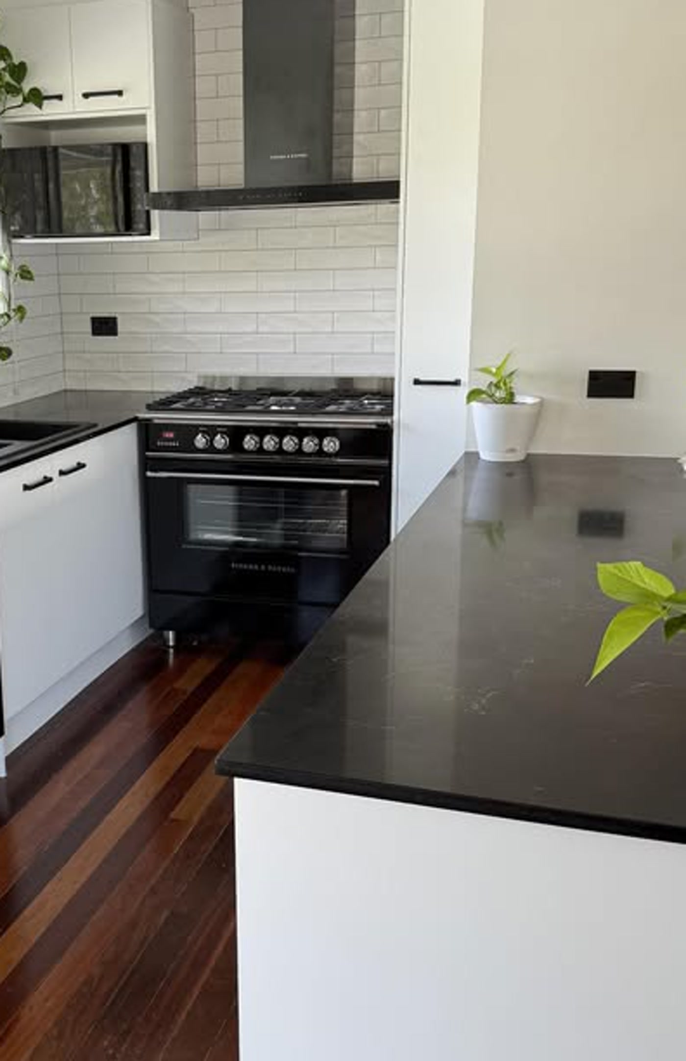 Black benchtop, white Shaker kitchen, subway tile splashback — PMG Cabinetry