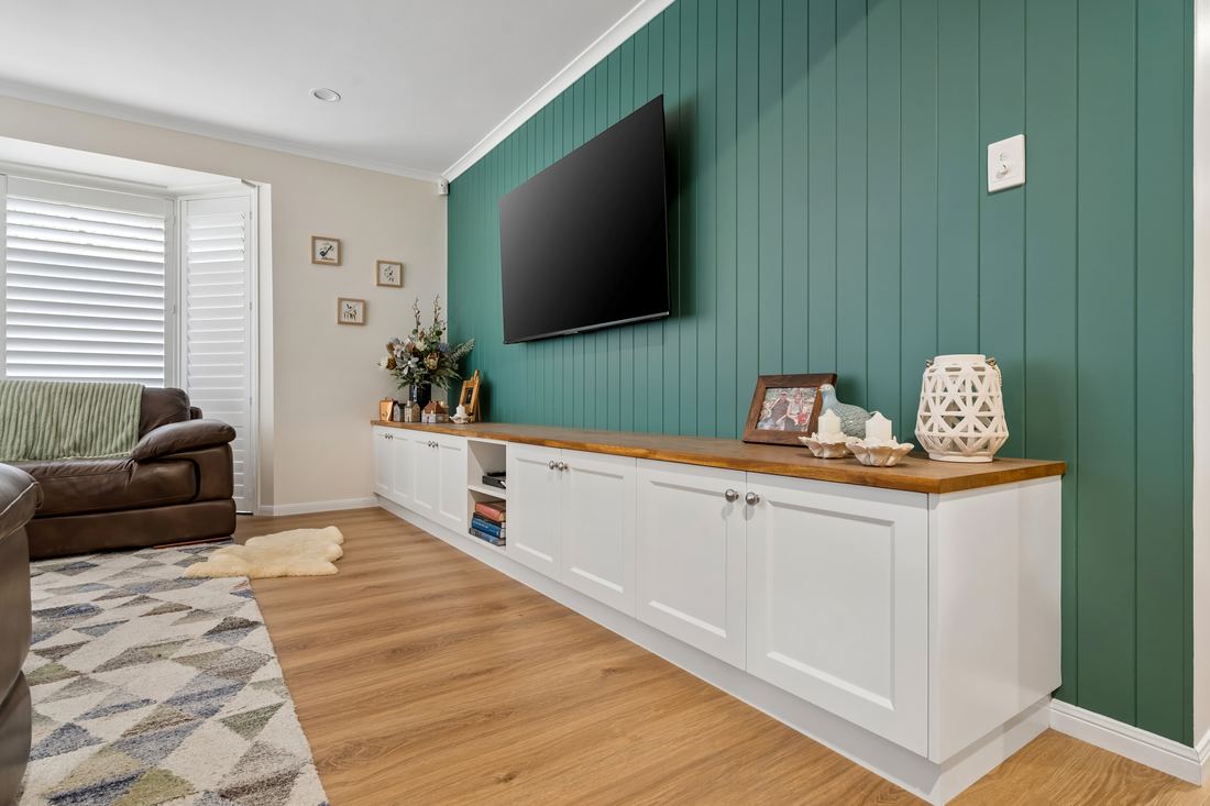 Built-in entertainment unit with green panelled feature wall and timber top — Placid Hills