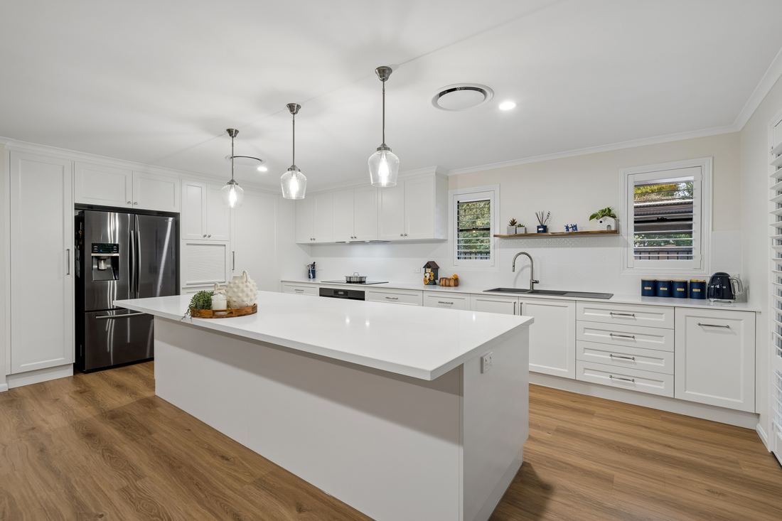 Stone island bench, pendant lighting and French-door fridge — Placid Hills kitchen